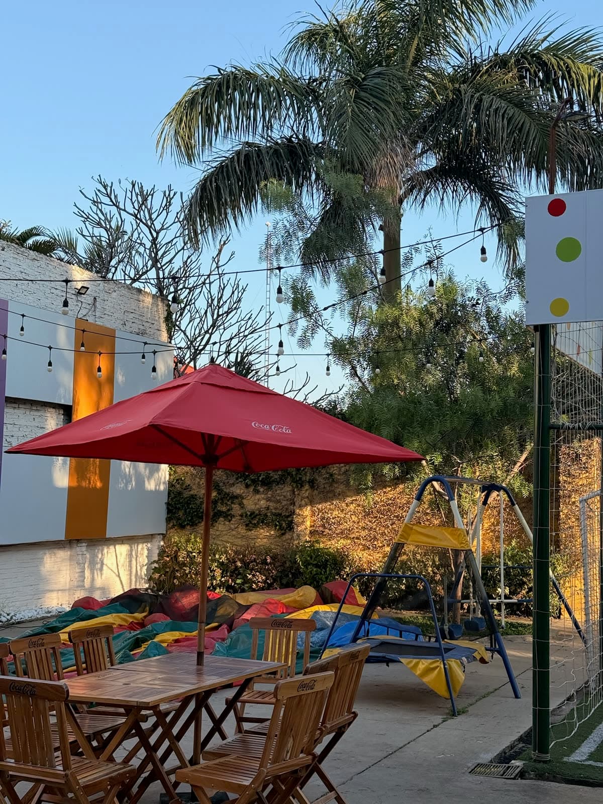 Patio al aire libre con mesas, sombrilla y luces